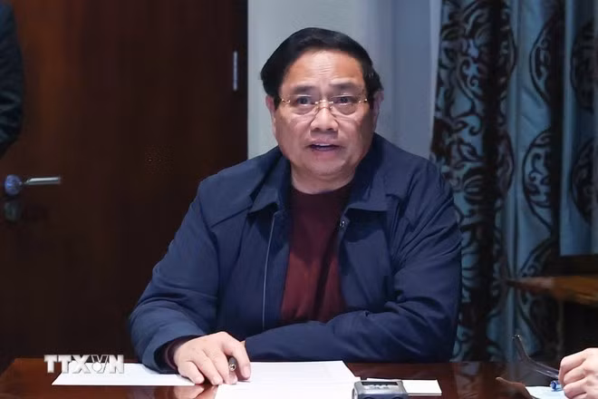 Thủ tướng Phạm Minh Chính chủ trì họp trực tuyến từ Nam Phi, chỉ đạo khắc phục hậu quả mưa lũ. (Ảnh: Dương Giang/TTXVN)