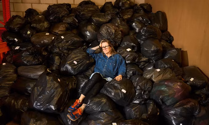 Wendy Ward với 2 tấn rác thời trang được thu gom trong ba ngày tại kho từ thiện của bệnh viện dưỡng lão St Luke ở Sheffield, Anh, ngày 29/4. Ảnh: The Guardian