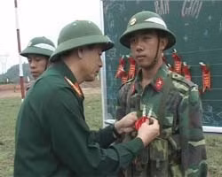 Đại tá Vũ Nam Phong - Chính ủy Bộ CHQS tỉnh - gắn hoa cho chiến sĩ bắn giỏi