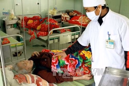 Nhân viên y tế kiểm tra sức khỏe cho người bệnh. Ảnh: TTXVN
