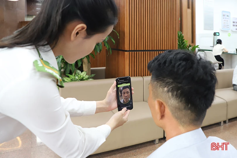 Anh Phạm Văn Trường (xã Thạch Hạ, TP Hà Tĩnh) được nhân viên ngân hàng hỗ trợ xác thực sinh trắc học.