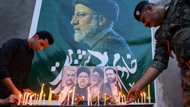 Người Iraq đặt hoa và thắp nến cho cố Tổng thống Iran Ebrahim Raisi và phái đoàn tháp tùng bên ngoài đại sứ quán Iran ở Baghdad ngày 20/5. Ảnh: AFP