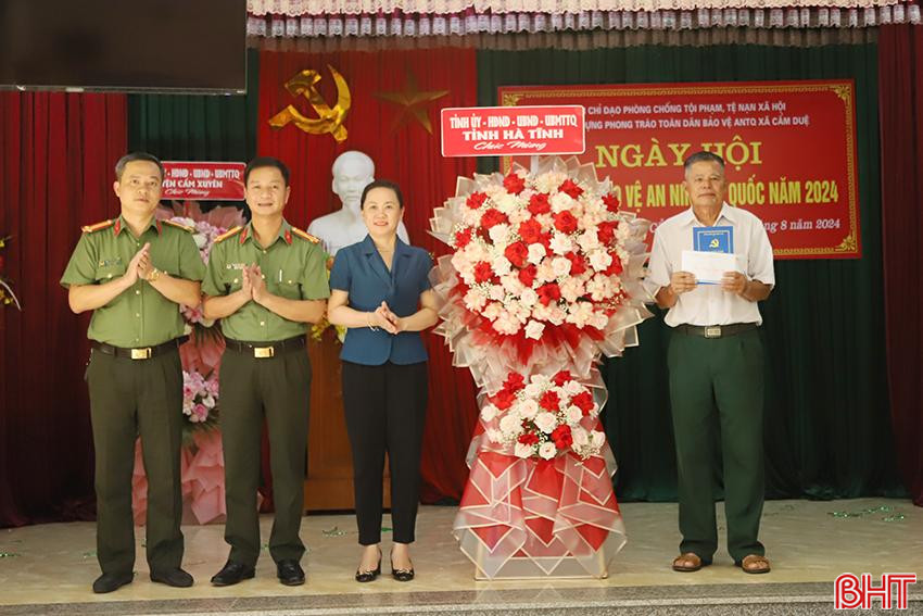 Tại buổi lễ, Trưởng ban Dân vận Tỉnh ủy Trương Thanh Huyền và đại diện Công an tỉnh tặng hoa chúc mừng cán bộ, đảng viên, Nhân dân thôn Phan Chu Trinh (xã Cẩm Duệ, Cẩm Xuyên).