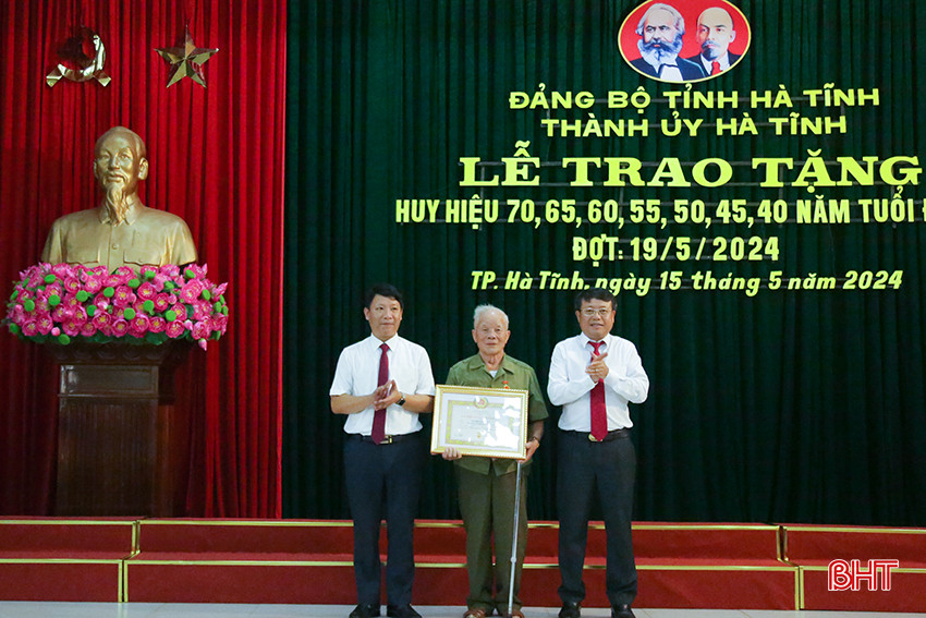 Phó Trưởng ban Thường trực Ban Tổ chức Tỉnh ủy Nguyễn Như Dũng, Bí thư Thành ủy Dương Tất Thắng trao Huy hiệu 65 năm tuổi Đảng cho đảng viên Nguyễn Xuân Đức.