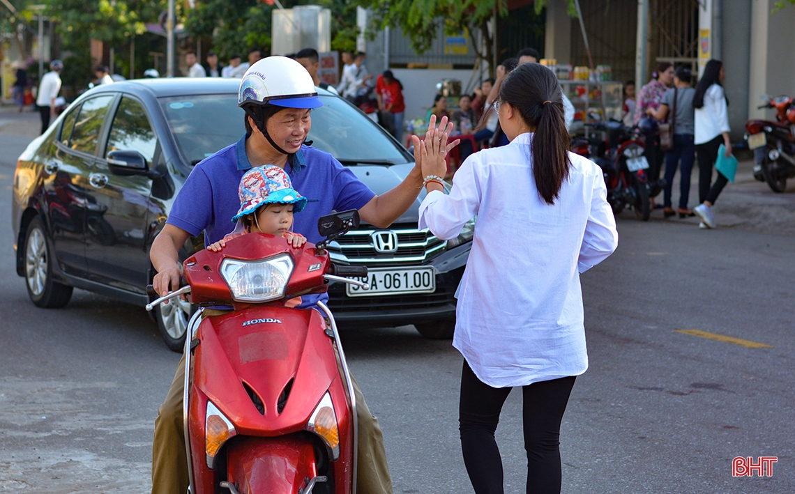 Phụ huynh “đội nắng” đồng hành cùng con trước cổng trường thi