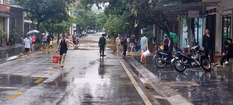 Người dân thành phố Hà Giang vệ sinh đường phố sau khi nước rút.