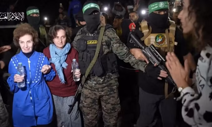 Các chiến binh Hamas bàn giao con tin cho Hội chữ thập đỏ ở Dải Gaza hôm 29/11/2023. Ảnh: AFP