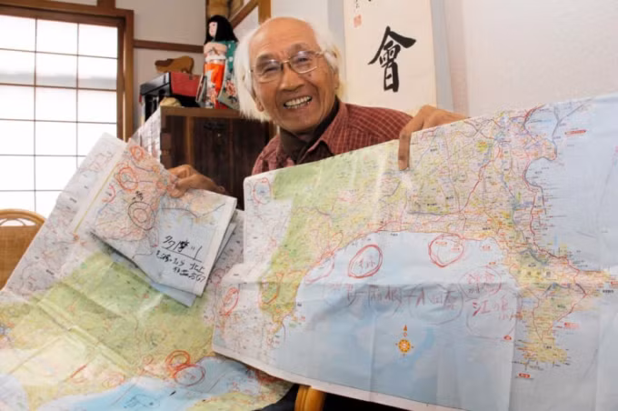 Cụ ông Mitsuo Tanigami và tấm bản đồ sử dụng để vượt 600 km từ Kobe đến Tokyo. Ảnh: Kobe Shimbun
