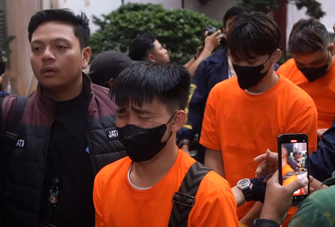 Cảnh sát Indonesia áp giải nghi phạm bị bắt trong cuộc đột kích ở Jakarta. Ảnh: AP