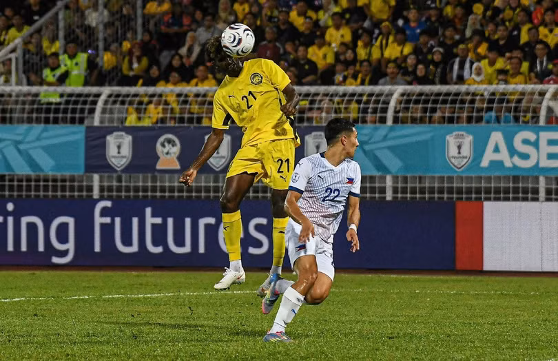 G. Pavithran của Malaysia (áo vàng) trong pha tranh chấp với cầu thủ Philippines tại ASEAN Cup.
