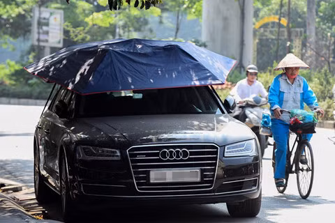 Sử dụng bạt che: Phim cách nhiệt và màn, rèm chỉ là biện pháp chống nóng cho nội thất xe nhưng nhiệt lượng vẫn có thể được hấp thụ từ thân xe. Do đó, chủ xe cần trang bị thêm tấm bạt phủ toàn bộ thân xe, sử dụng khi dừng đỗ xe ngoài trời, đặc biệt là nếu phải đỗ xe ngoài nắng. Ngoài tấm bạt phủ kín xe truyền thống, thị trường đã xuất hiện thêm một loại ô che nắng cho khoang ca-bin. Loại ô che nắng này có thể điều khiển bằng remote và có giá khoảng 4-5 triệu. Ảnh: Việt Linh. Các biện pháp “hạ nhiệt” cho ôtô trong đợt nắng nóng kỷ lục