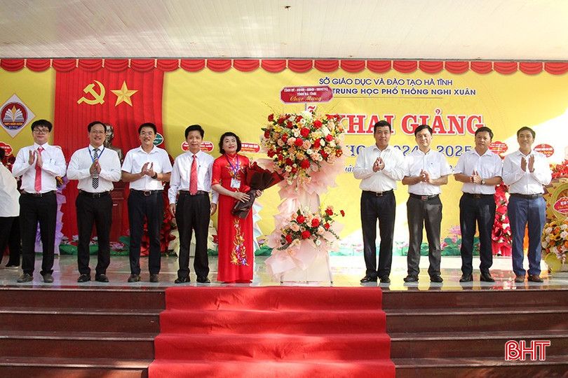 Phó Chủ tịch Thường trực HĐND tỉnh Trần Tú Anh tặng hoa chúc mừng nhà trường.