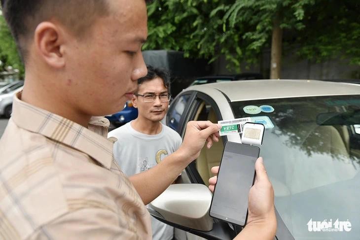 Tài xế đăng ký dán thẻ thu phí tự động VETC - Ảnh: NGỌC PHƯỢNG