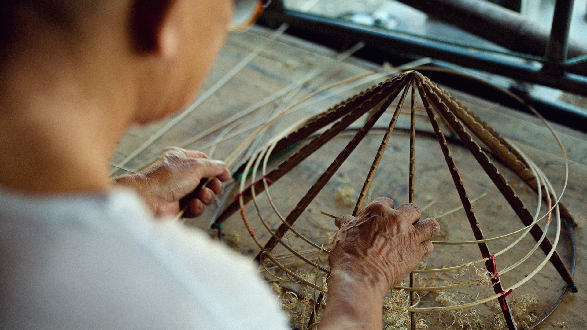 Khi lá đã được làm phẳng, tôi bắt đầu ướm những vành tre lên khuôn để tạo dáng cho chiếc nón. Các vành phải được sắp xếp cân đối, đều nhau để nón có độ tròn và dáng đẹp. Đây là công đoạn quan trọng, quyết định hình dáng của chiếc nón trước khi xếp lá và khâu hoàn thiện.