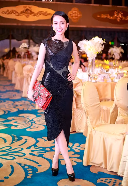 Bộ đầm kết họa tiết trái tim từ những chất liệu khác nhau của Đỗ Mạnh Cường giúp Linh Nga tôn nét sang trọng, nữ tính. "Chim công làng múa" khéo chọn clutch Gucci gam đỏ nổi bật để làm điểm nhấn trên nền đen bí ẩn.