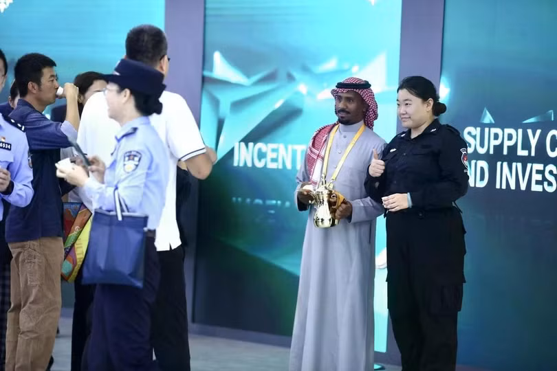 Một nhân viên Trung Quốc chụp ảnh lưu niệm cùng đại diện gian hàng Saudi Arabia. Ảnh: Guanhailou.