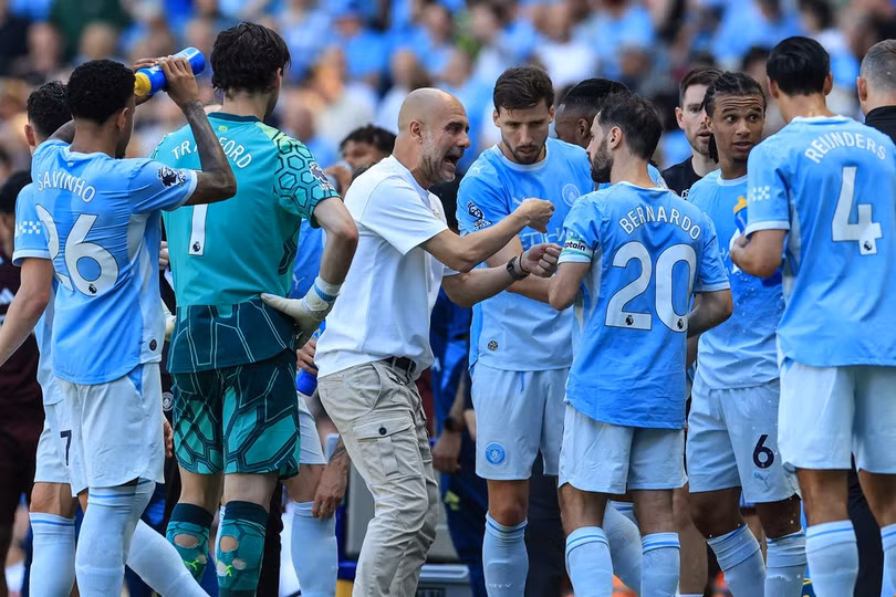 HLV Pep Guardiola trao đổi với tiền vệ Bernardo Silva trong quãng nghỉ uống nước ở trận Man City gặp Aston Villa trên sân Etihad, vòng cuối Ngoại hạng Anh ngày 24/5/2026. Ảnh: AFP