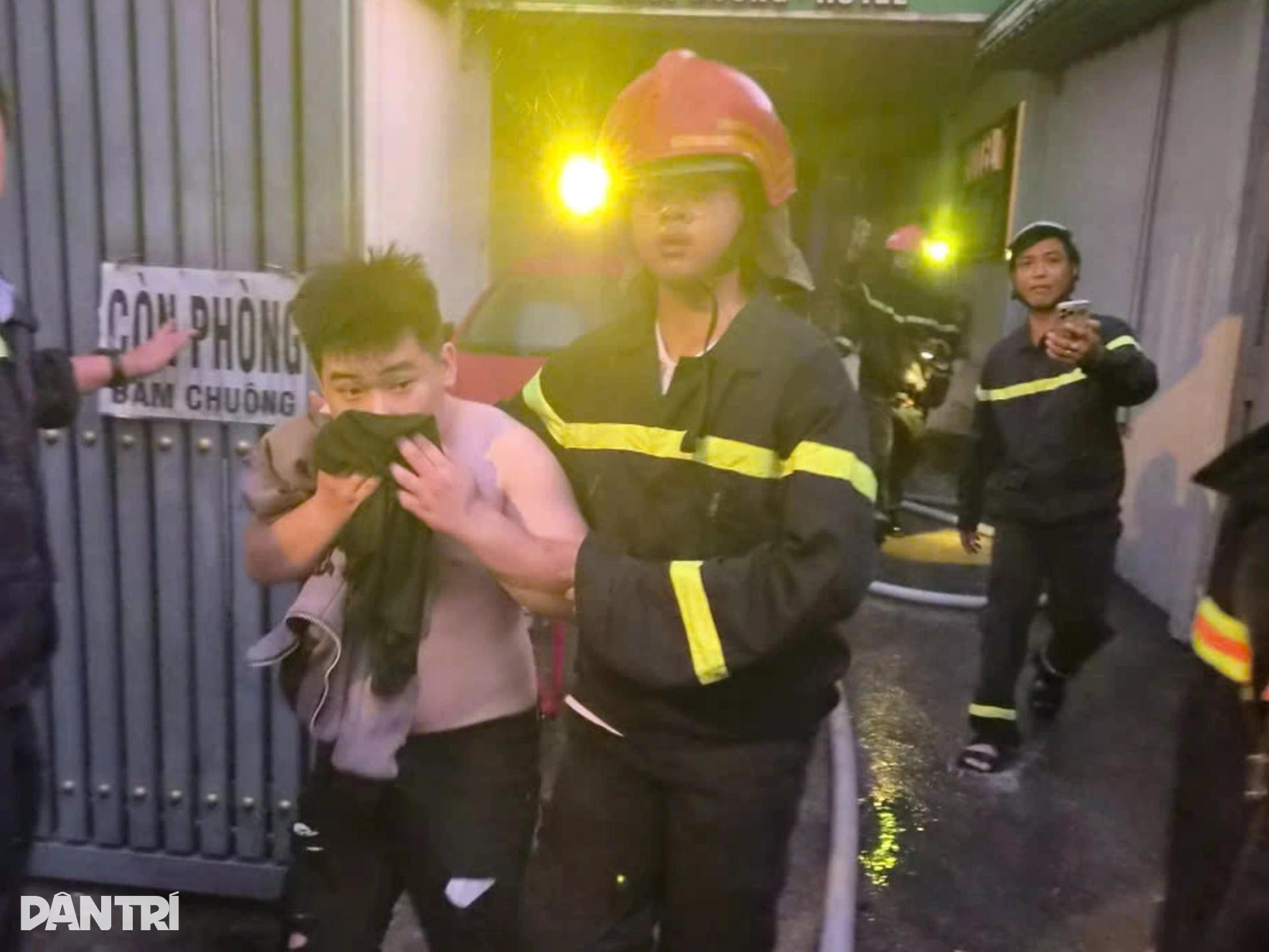 Một thiếu niên dùng áo che mũi, được cảnh sát giải cứu, di chuyển rời khỏi khách sạn (Ảnh: Thuận Thiên).