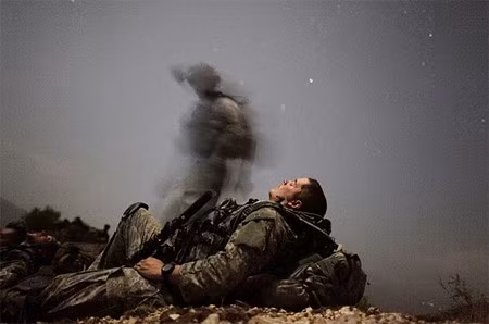 Chàng lính Mỹ ngả lưng nghỉ ngơi trong cuộc tuần tra đêm ở thung lũng Pesh, Afghanistan. Ảnh: Reuters.