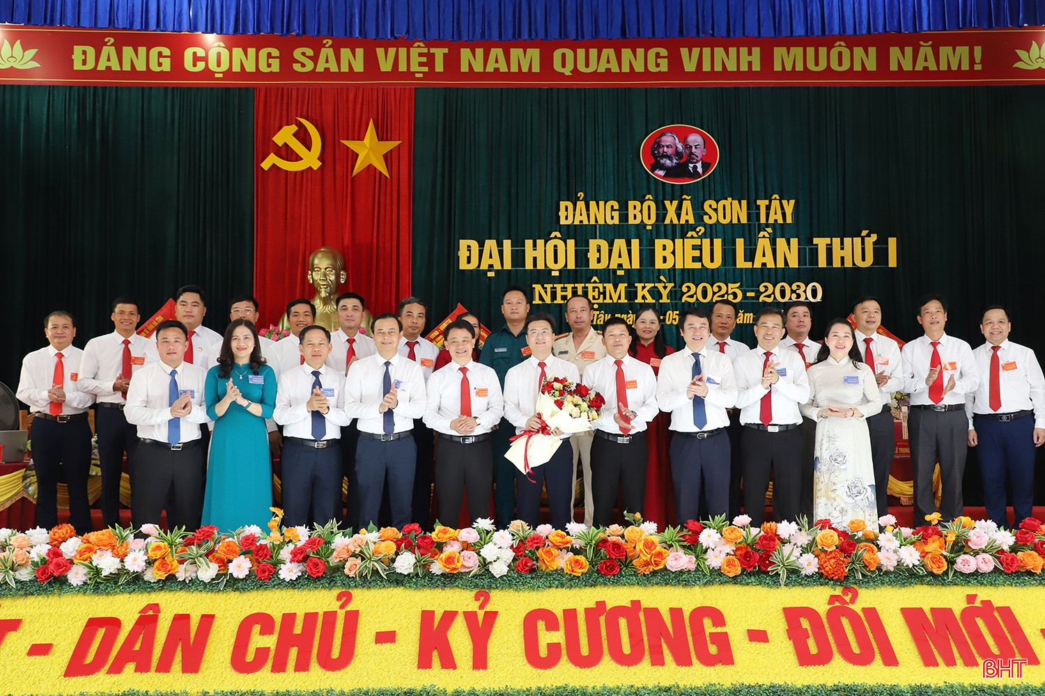 Thứ trưởng Bộ Ngoại giao Lê Anh Tuấn, và đại biểu tặng hoa chúc mừng Ban Chấp hành Đảng bộ xã Sơn Tây nhiệm kỳ 2025 - 2030.
