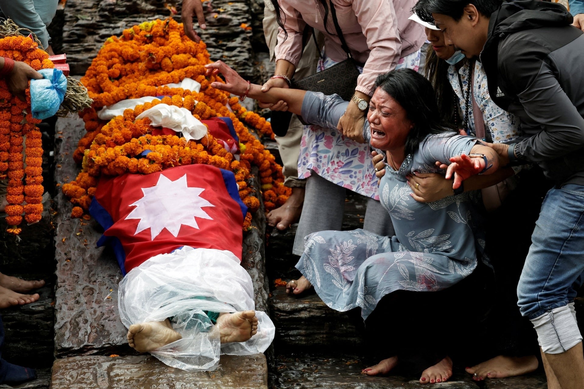 Rashik Khatiwada (23 tuổi) thiệt mạng trong cuộc biểu tình ở Kathmandu, Nepal. Mẹ anh khóc trong lễ hỏa thiêu thi thể con trai tại đền Pashupatinath, nằm bên bờ sông Bagmati, ngày 16/9.
