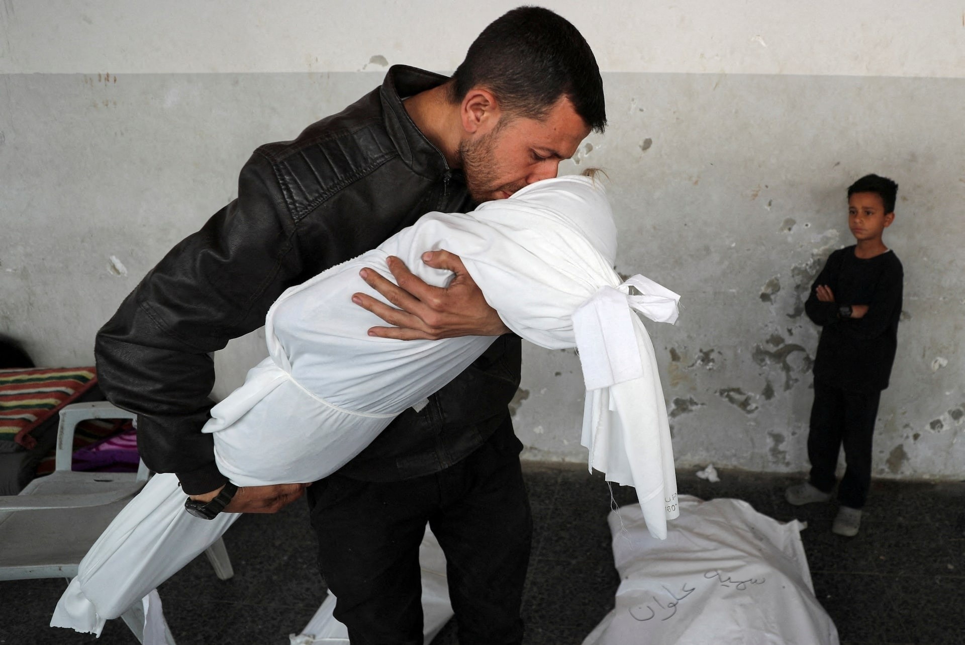 Người đàn ông Palestine hôn từ biệt cháu trai, cậu bé Nour Nabhan (5 tuổi). Nour thiệt mạng trong vụ không kích do Israel tiến hành tại Dải Gaza ngày 21/5.