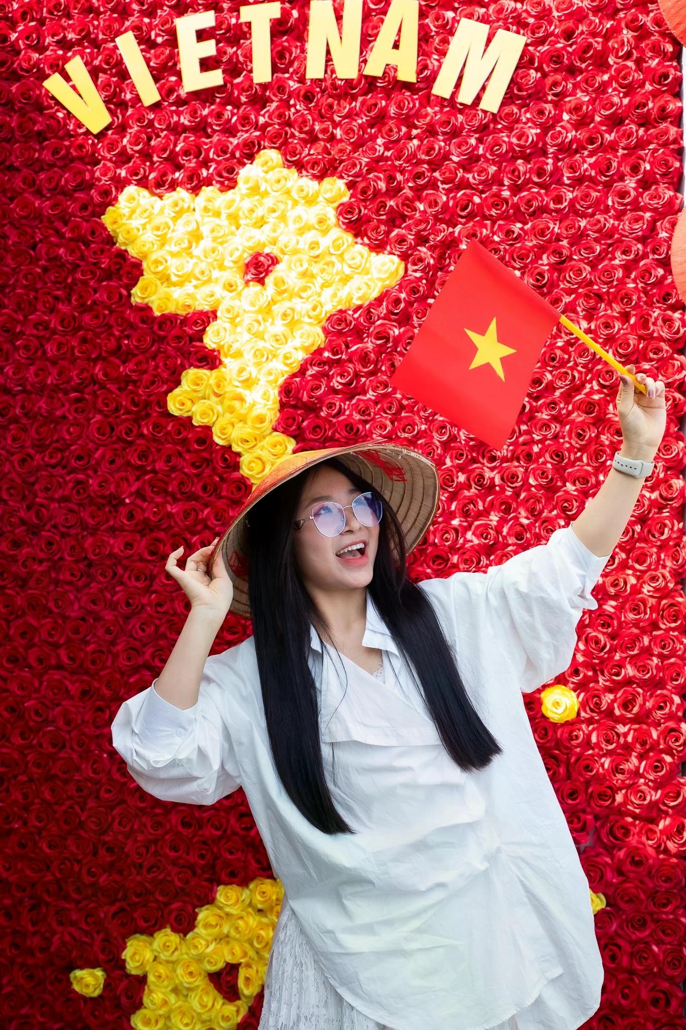 Diệu Thanh (sinh năm 2001, quê Hải Dương) biết đến quán qua mạng xã hội và tranh thủ một ngày nghỉ để lên Hà Nội check-in. "Tường hoa ghép bản đồ Việt Nam và lá cờ đỏ sao vàng thực sự gây xúc động. Tôi thấy xứng đáng dù phải đứng giữa nắng hơn 30 phút để chụp ảnh. Nhìn vào bức ảnh, tôi cảm thấy như đang hòa mình vào một phần của câu chuyện dân tộc", Thanh bộc bạch.