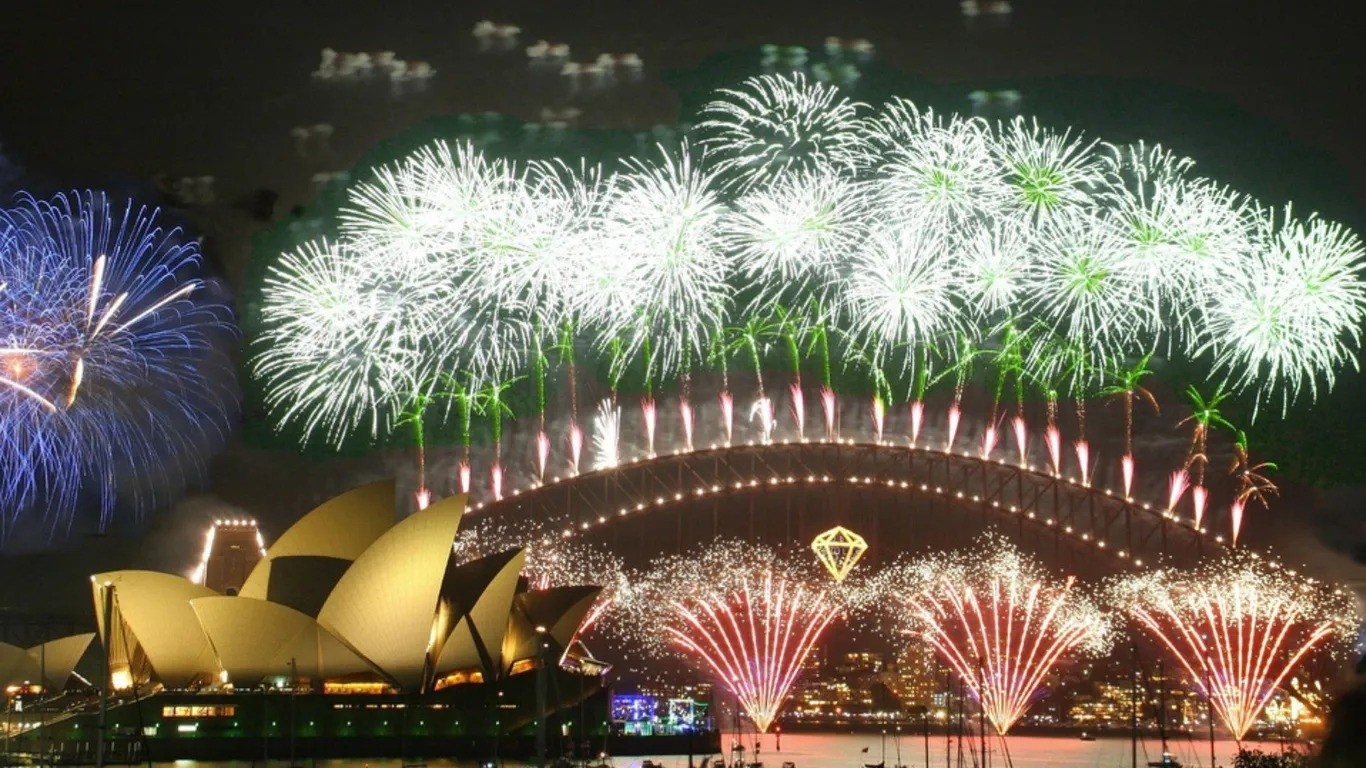 Theo Travel+Leisure, chuỗi hoạt động đón năm mới tại Sydney sẽ được dàn dựng công phu, xứng đáng nằm trong top những lễ hội giao thừa hàng đầu thế giới. Pháo hoa được bắn từ Cầu cảng Sydney, Nhà hát Opera và các sà lan trên vịnh, thậm chí còn tạo hiệu ứng “thác nước ánh sáng” đổ xuống từ cây cầu lịch sử xây dựng năm 1932. Mặt nước cảng phản chiếu bầu trời rực sáng, tạo nên khung cảnh ngoạn mục khó quên. Pháo hoa đêm giao thừa tại Sydney. Ảnh: Rob Chandler.