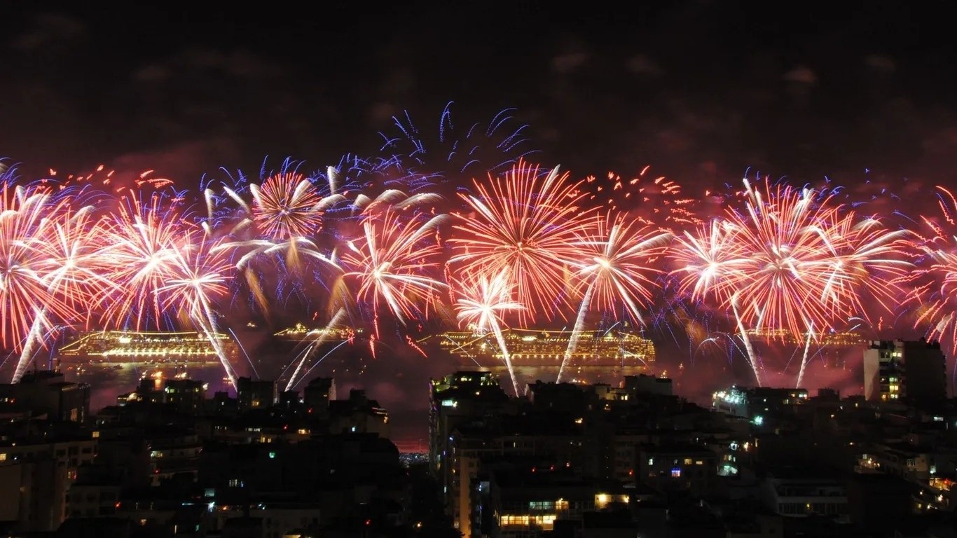 Lễ đón năm mới tại Rio de Janeiro không chỉ dừng lại ở ánh sáng và pháo hoa, mà còn cả bữa tiệc Réveillon cuồng nhiệt, bắt đầu ngay từ lúc hoàng hôn ngày 31/12. Trống samba rộn ràng, âm nhạc sống động và biển người hào hứng cùng chờ đón khoảnh khắc giao thừa. Bãi biển Copacabana ở Rio de Janeiro là trung tâm của lễ đón năm mới, thu hút hàng triệu người dân và du khách từ khắp nơi. Mọi người mặc trang phục trắng - biểu tượng của hòa bình và may mắn - cùng nhau nhảy múa và chiêm ngưỡng màn pháo hoa ngoạn mục trên nền biển đêm. Khi kim đồng hồ chạm mốc nửa đêm, những màn pháo hoa huyền ảo thắp sáng bầu trời và phản chiếu lung linh trên những con sóng của bãi biển Copacabana. Réveillon 2013 tại bãi biển Copacabana. Ảnh: Leandro Neumann Ciuffo.