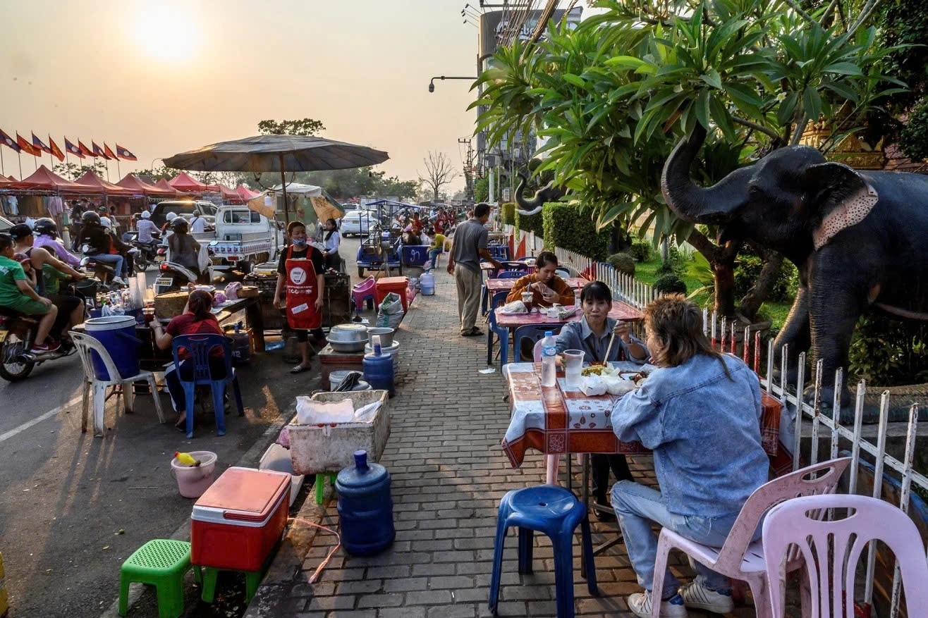 Người dân thưởng thức đồ ăn đường phố ở Viêng Chăn. Ảnh: Mladen Antonov.