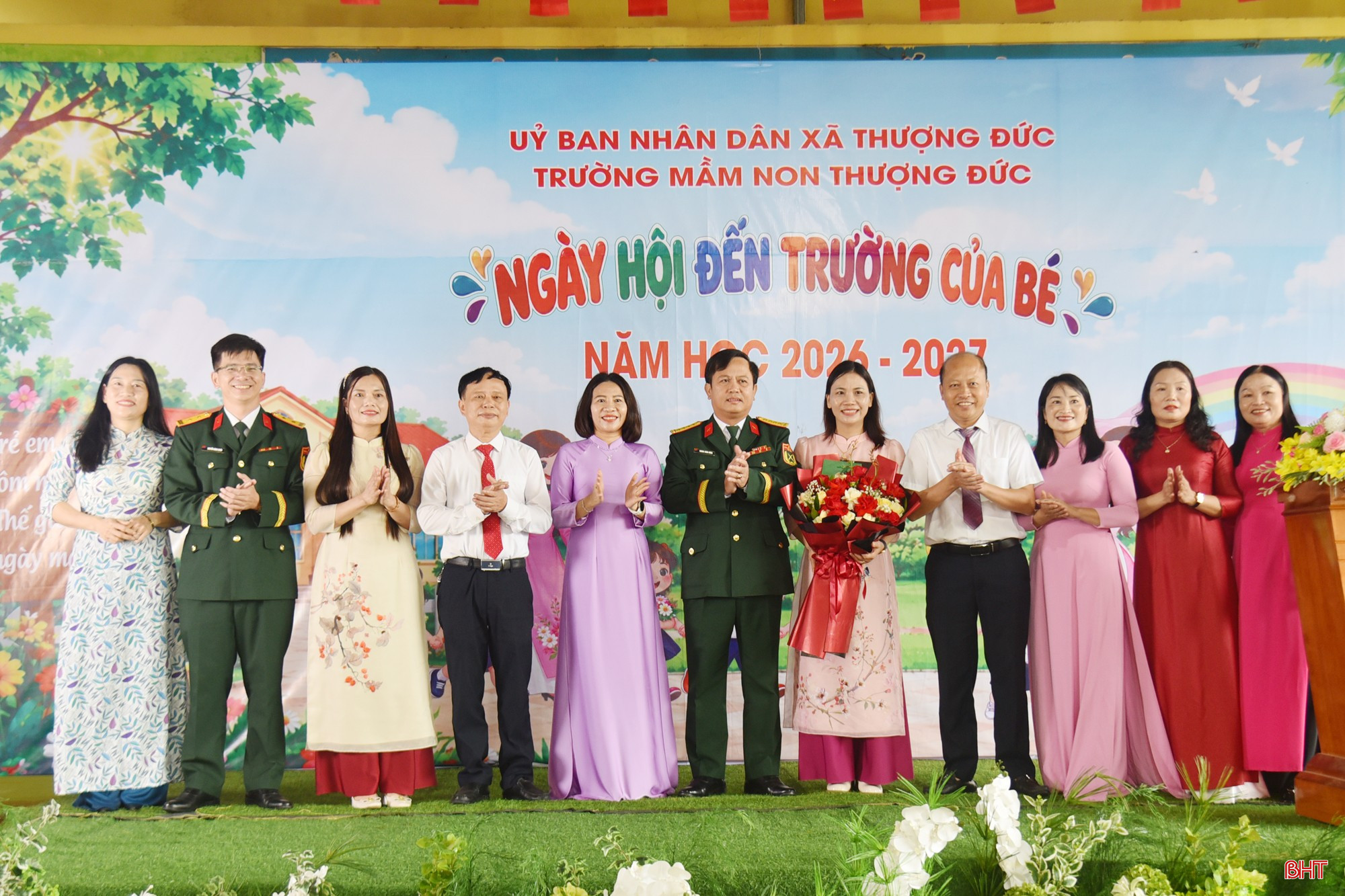 Đại tá Hoàng Xuân Đông tặng hoa, chúc mừng tập thể giáo viên Trường Mầm non Thượng Đức.