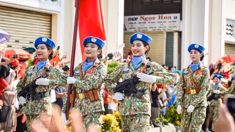 Khối Sĩ quan Cảnh sát gìn giữ hòa bình Liên hợp quốc đi qua chợ Bến Thành. (Ảnh: THÀNH ĐẠT)