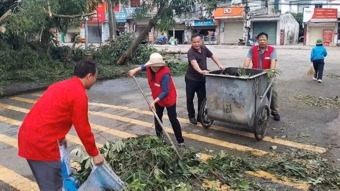 Các cán bộ, tình nguyện viên Hội Chữ thập đỏ tỉnh Hà Tĩnh hỗ trợ người dân thu dọn sau bão số 5.