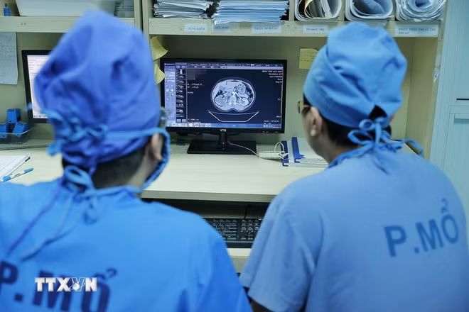 Các bác sỹ Bệnh viện Đại học Y Hà Nội xem hồ sơ bệnh án của bệnh nhân trước khi vào phẫu thuật. (Ảnh: Minh Quyết/TTXVN)