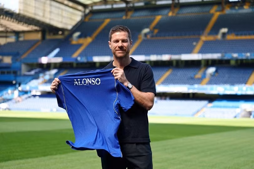 Xabi Alonso cầm áo đấu của Chelsea trong lễ ra mắt cương vị HLV trưởng tại sân Stamford Bridge, London (Anh), ngày 13/7/2026. Ảnh: Reuters
