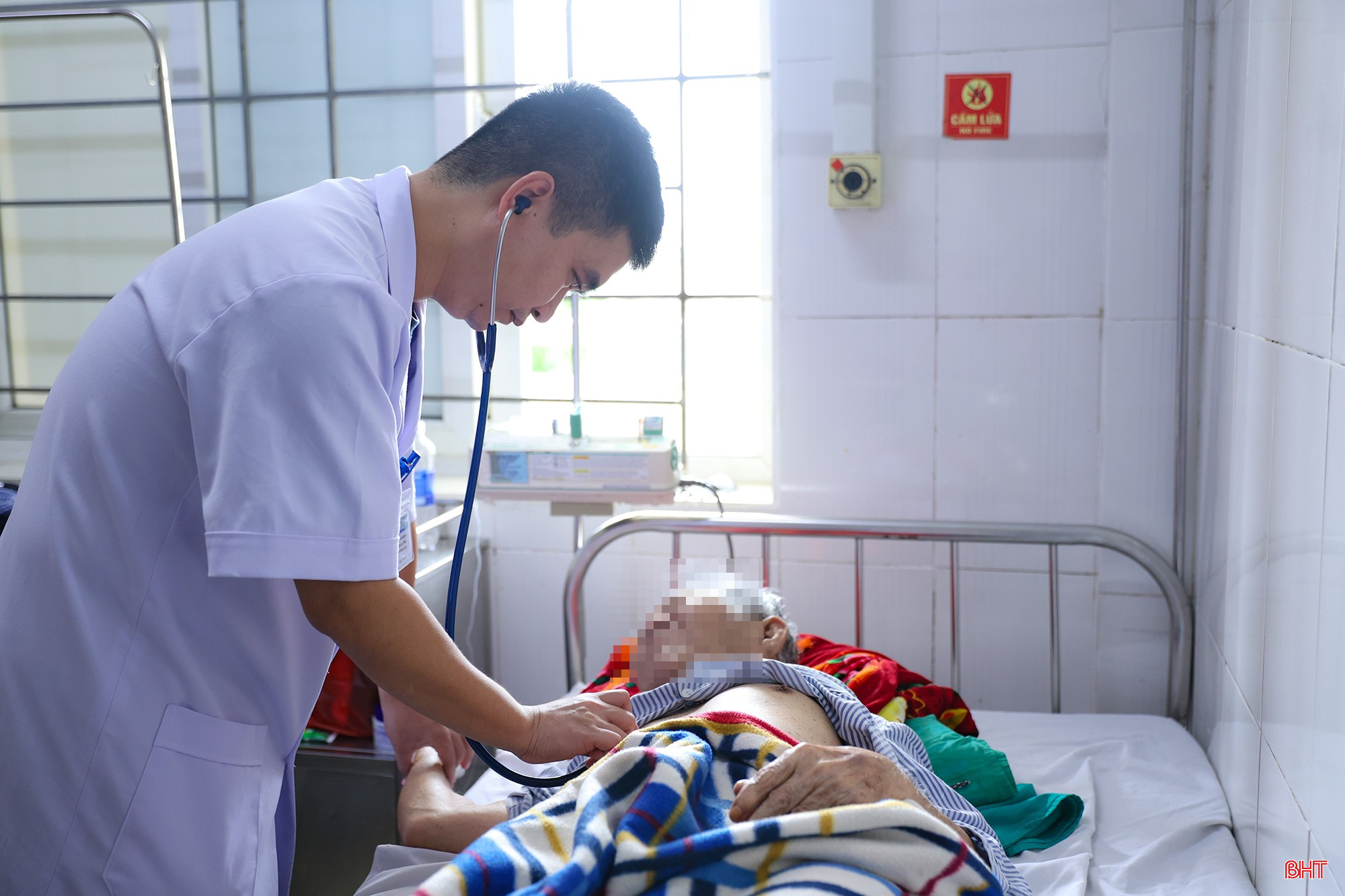 Bác sĩ CKI Lê Chí Hướng thăm khám cho người bệnh sau can thiệp mạch.