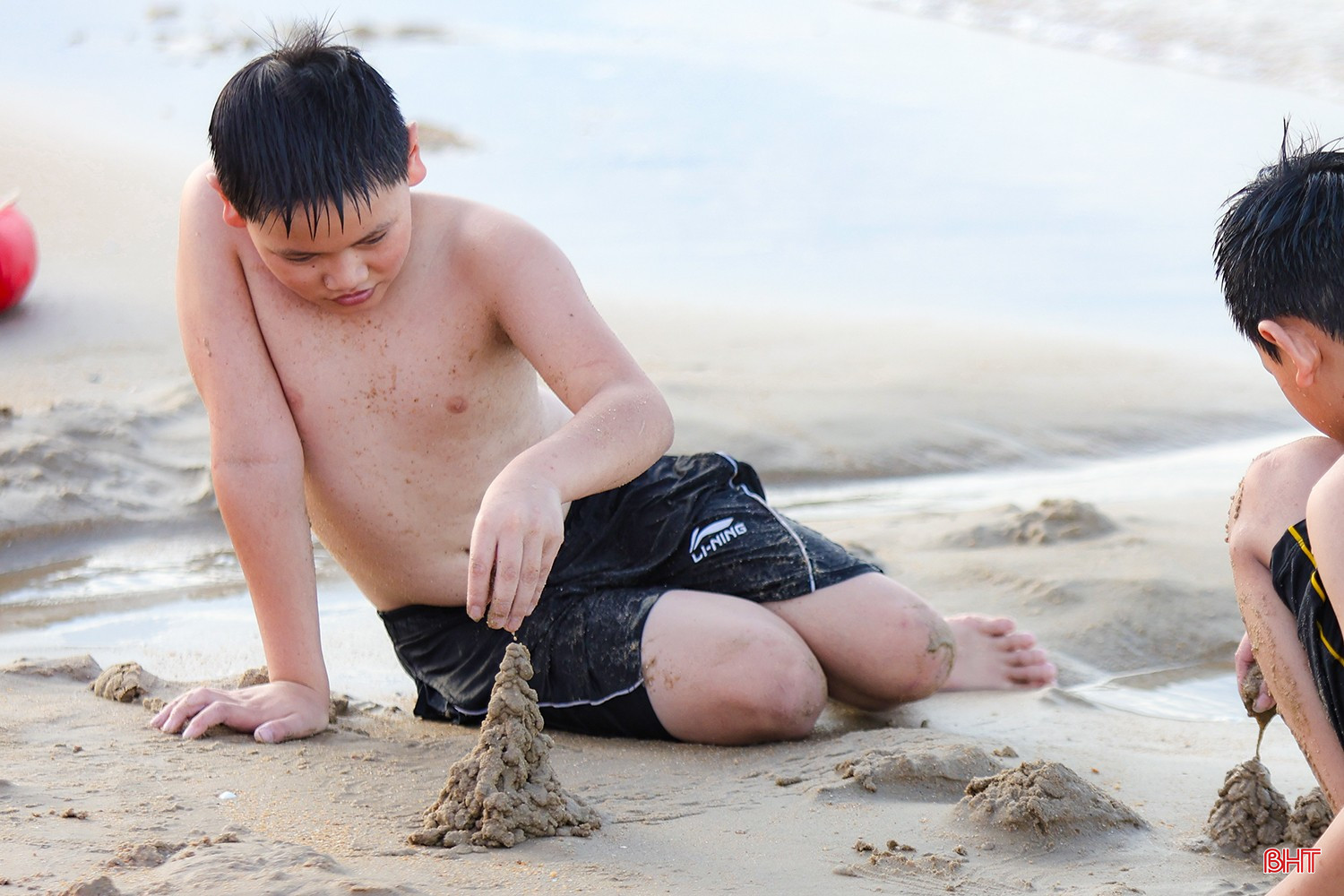 Những em nhỏ mải mê xây lâu đài cát.