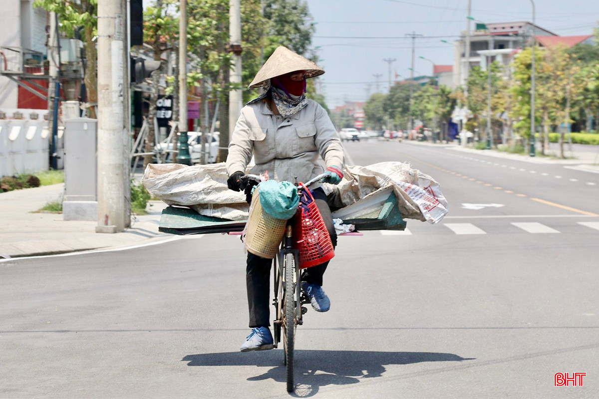 Người phụ nữ che kín người để bảo vệ sức khoẻ giữa tiết trời nắng gắt.