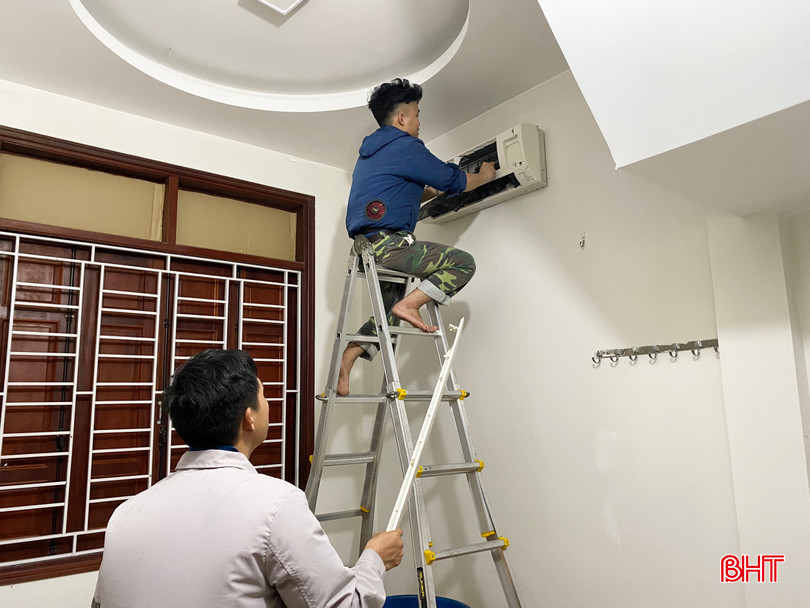 Anh Lê Huy (áo xanh) trực tiếp lắp đặt và sửa chữa điều hoà cho khách hàng. Ảnh 3.jpg