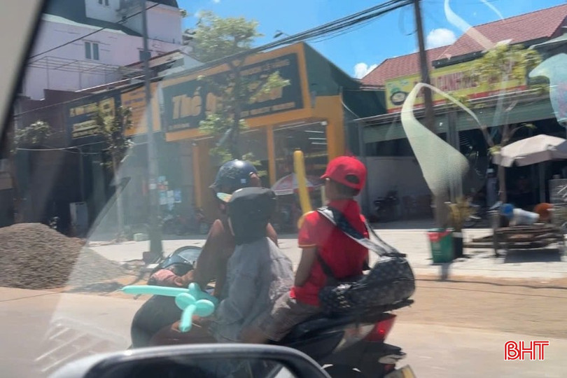 Nhiều học sinh ngồi sau xe phụ huynh không được trang bị mũ bảo hiểm. bqbht_br_x.jpg