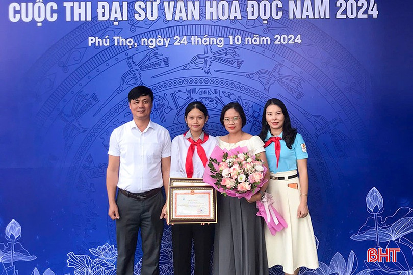 Em Lê Anh Thư và mẹ cùng thầy Nguyễn Trần Quảng (Hiệu trưởng Trường THCS Mỹ Duệ), cô tổng phụ trách đội chụp ảnh lưu niệm tại lễ trao giải. a2-5792-481.jpg