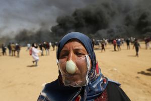 Người Palestine đeo mặt nạ hành tây đối phó với lựu đạn hơi cay của binh lính Israel