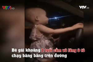 Bé gái khoảng 2 tuổi cầm vô lăng ô tô chạy băng băng trên đường