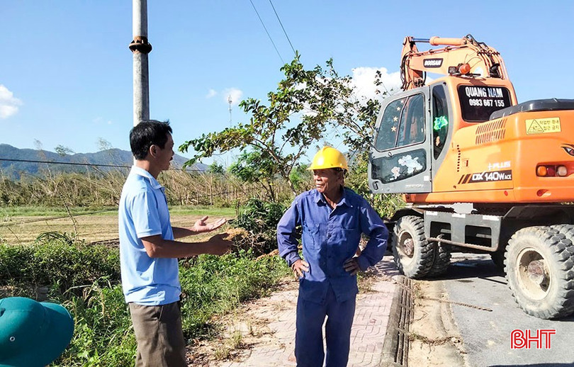 Cán bộ Trung tâm Nước sạch và VSMTNT tỉnh (bên trái) trao đổi với tổ công nhân lắp đặt lại hệ thống cột điện bị gãy đổ sau bão số 10, bên tuyến đường lên chùa Hương Tích trong chiều 3/10. bqbht_br_a7.jpg