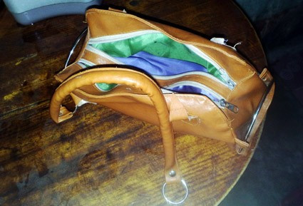 Chiếc túi xách bị bọn cướp gật đứt quai, sau khi lấy hết tài sản, bọn chúng vứt lại bên đường