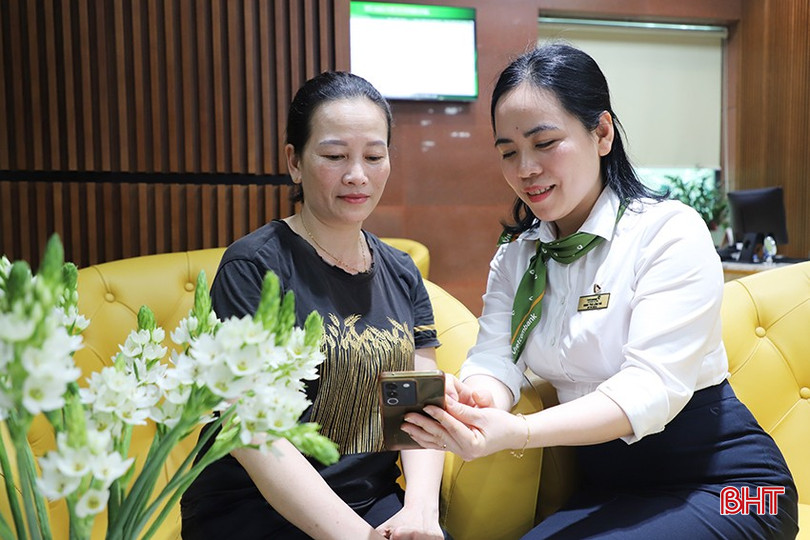 Nhân viên Vietcombank Hà Tĩnh hướng dẫn khách hàng sử dụng ngân hàng số. bqbht_br_78.jpg