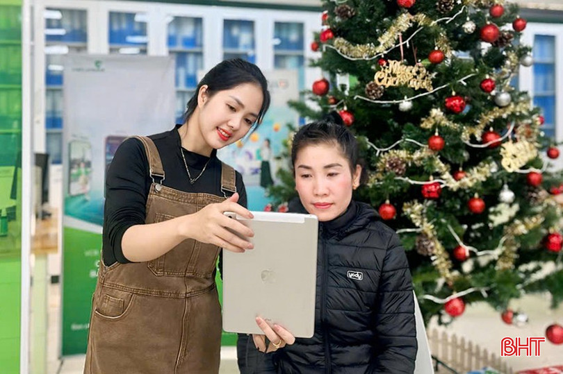 Nhân viên Vietcombank Bắc Hà Tĩnh hỗ trợ khách hàng cài đặt sinh trắc học và cảnh báo các "chiêu trò" lừa đảo dịp cuối năm. bqbht_br_z6154074601494-2ef52aaaef15f3c4f3bd595c4557d199.jpg