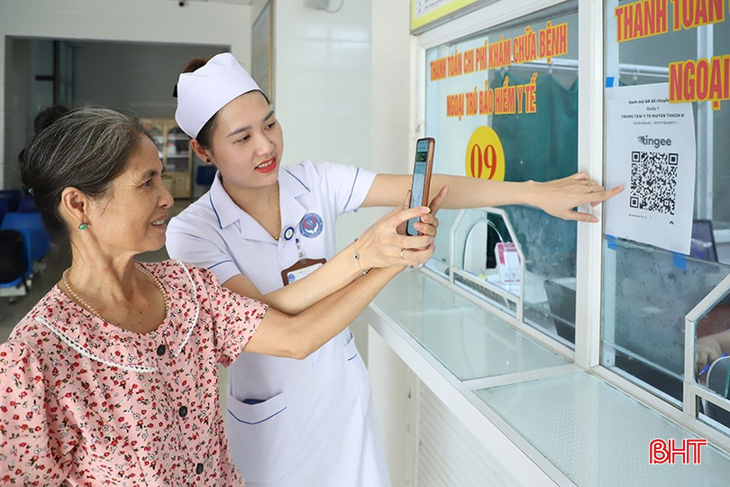 Cán bộ Trung tâm Y tế Thạch Hà hướng dẫn bệnh nhân cao tuổi thanh toán viện phí qua quét mã QRCode. bqbht_br_45.jpg