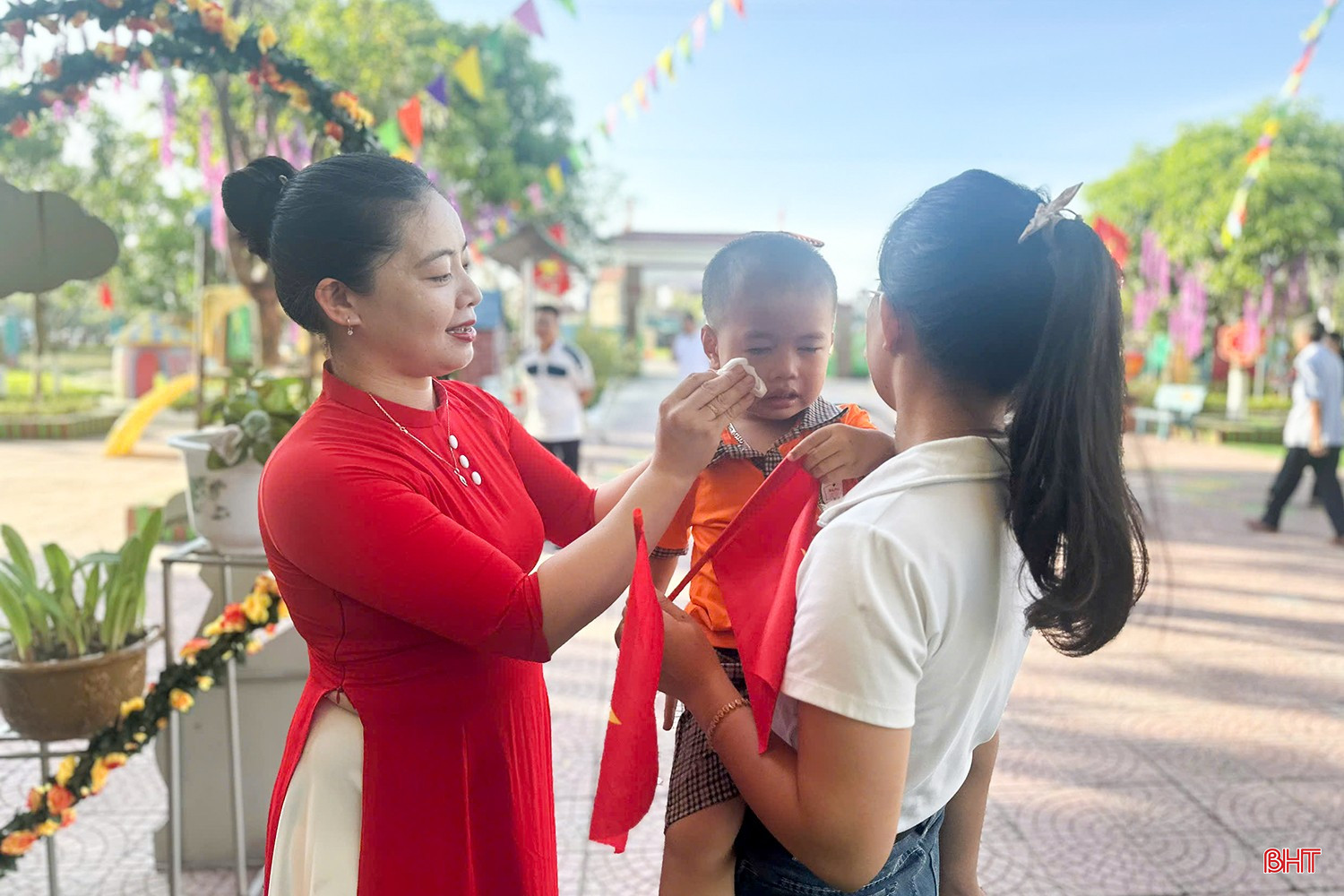Manche Kinder klammern sich noch immer an die Arme ihrer Mutter. Một số em nhỏ vẫn bịn rịn trong vòng tay mẹ.