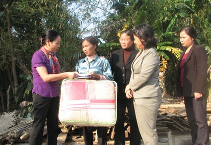 Lãnh đạo Hội LHPN tỉnh và Nhà văn hoá phụ nữ TP HCM tặng quà cho gia đình chị Hoàng Thị Hà, xã Đức Bồng (Vũ Quang)